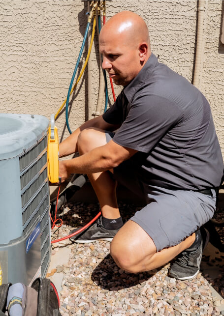 A Paragon Service Pros technician repairs an air conditioner.